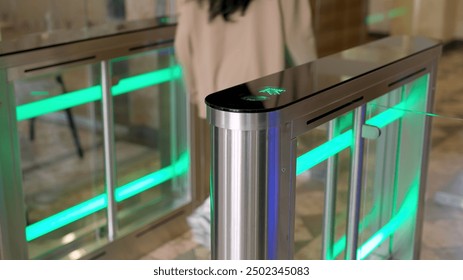 A confident businesswoman effortlessly passes through a modern turnstile using her personal access card in a sleek office lobby. Ideal for concepts of advanced security, workplace technology. - Powered by Shutterstock