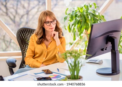 Confident businesswoman looking thoughtfully while sitting behind her computer and working. Home office. - Powered by Shutterstock