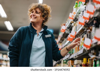 Confident Businesswoman Standing By The Shelves And Smiling In Supermarket. Female Manager At A Grocery Store.