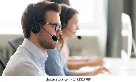 Confident call center operator agent in headset with microphone consulting client online close up, busy employee working in customer support service office, coworking space, horizontal photo