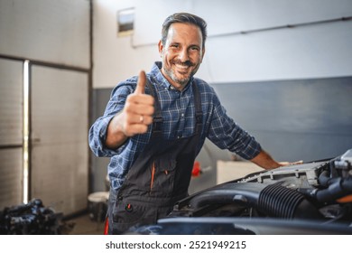 A confident car mechanic smile and give a thumbs up while leaning on a car engine, showcasing his competence and the quality of his work in a well-lit workshop - Powered by Shutterstock