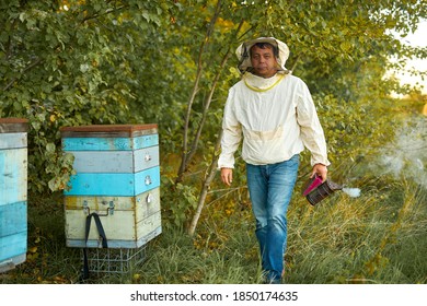 confident caucasian male beekeeper working to collect honey. organic beekeeping in rural area concept - Powered by Shutterstock