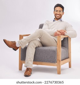 Confident, chair and portrait of entrepreneur sitting happy with a smile and crossed legs isolated in studio white background. Gentleman, relax and professional or proud male employee or business man - Powered by Shutterstock