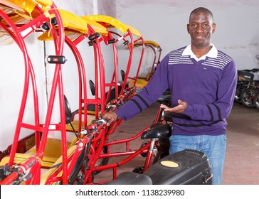 Confident cheerful African-American man recommending traveling with rickshaw