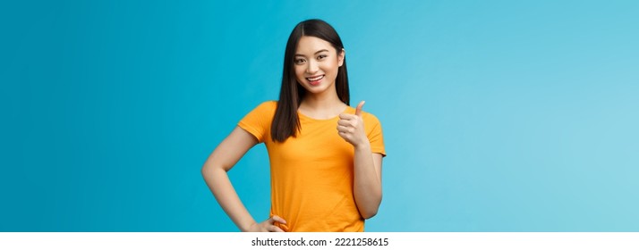 Confident Cheerful Asian Brunette Girl Show Thumb-up Satisfied, Give Approval, Liking Good Choice, Smiling Delighted, Accept Your Plan, Positive Judgement, Stand Blue Background. Copy Space