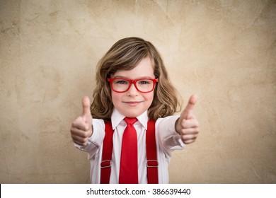 Confident child businessman showing thumbs up. Success winner business concept