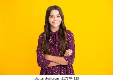 Confident Child Keep Arms Crossed, Isolated On Yellow Background, Empty Space. Little Caucasian Teenage Girl 12, 13, 14 Years Old Hold Hands Crossed. Children Studio Portrait. Childhood Lifestyle.