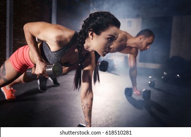 Confident couple working out with dumbbell - Powered by Shutterstock