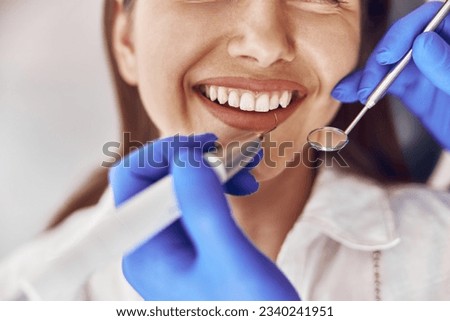 confident doctor is making ultrasonic tooth stone cleaning in modern dental cabinet