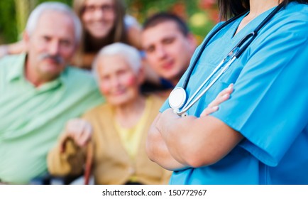 Confident Doctor Welcoming Patients, Happy Family Members - Family Medical Care Concept.