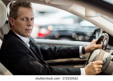 Confident Drive. Side View Of Confident Senior Man In Formalwear Sitting In Car And Looking At Camera