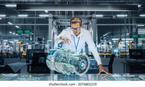 Confident Engineer In White Shirt Working On Jet Engine With Use Of Augmented Reality Hologram In An Office At Plane Assembly Plant. Industrial Specialist Working In Technological Development Facility