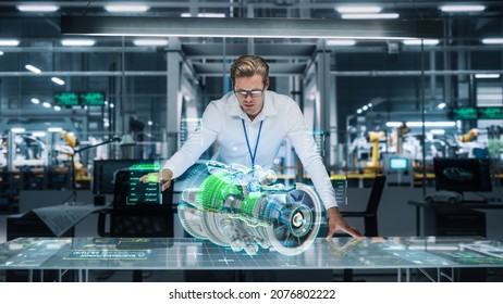 Confident Engineer In White Shirt Working On Jet Engine With Use Of Augmented Reality Hologram In An Office At Plane Assembly Plant. Industrial Specialist Working In Technological Development Facility