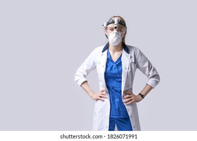 Confident ENT Doctor Surgical Headlight Head Light. Portrait Of Female Otolaryngologist Or Head And Neck Surgeon On Light Grey Background.