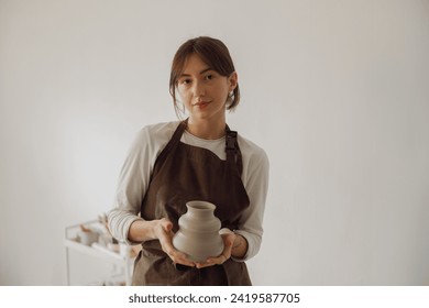 Confident entrepreneur crafts woman in pottery studio looking at camera  - Powered by Shutterstock