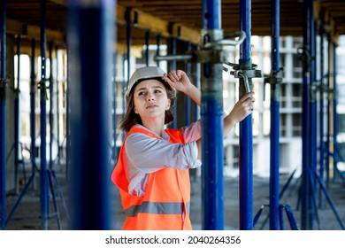 Confident Female Builder Checks Fastenings On A Monolithic Structure. Construction Concept.