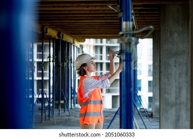 Confident Female Builder Checks Fastenings On A Monolithic Structure. Construction Concept.