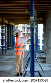 Confident Female Builder Checks Fastenings On A Monolithic Structure. Construction Concept.