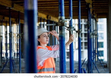 Confident Female Builder Checks Fastenings On A Monolithic Structure. Construction Concept.