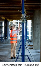 Confident Female Builder Checks Fastenings On A Monolithic Structure. Construction Concept.