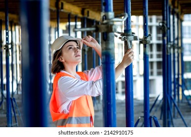 Confident Female Builder Checks Fastenings On A Monolithic Structure. Construction Concept.