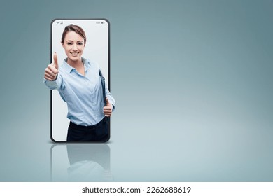 Confident female business executive giving a thumbs up in a smartphone videocall and smiling, online  service concept - Powered by Shutterstock