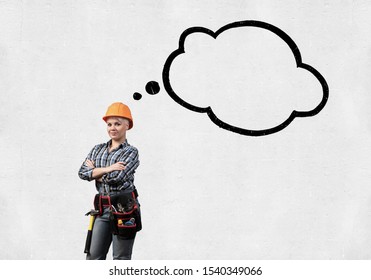 Confident Female Construction Worker In Safety Helmet Standing With Folded Arms. Attractive Young Woman With Empty Speech Bubble Above Head On White Background. Business Idea Generation Concept