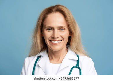 Confident female doctor in lab coat and stethoscope. Smiling against blue background. Radiates positivity and professionalism. Perfect for medical concepts.  Healthcare. Wellness. Prevention. Support - Powered by Shutterstock