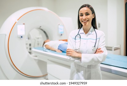 Confident female doctor oncology in magnetic resonance imaging or computed tomography room of a modern hospital.