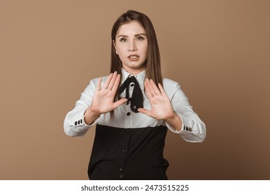 Confident Female Executive Extending Arms Forward in a Stop Gesture, Signifying an End to Conversation. Non-verbal Expression of Ceasing Dialogue and Asserting Control - Powered by Shutterstock