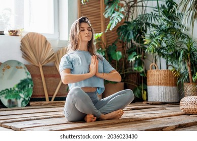 A confident female instructor is engaged in yoga in the asana pose. The harmony of Zen in the soul and body. Sports fortitude, exercises for health. Aerobics trainer warming up joints and muscles. - Shutterstock ID 2036023430