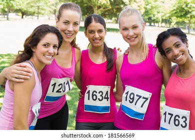 Confident female participants of breast cancer marathon standing together in park