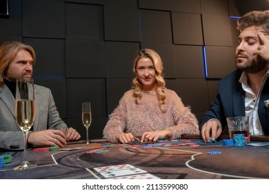 Confident Female Poker Player Sitting At Gaming Table In Casino