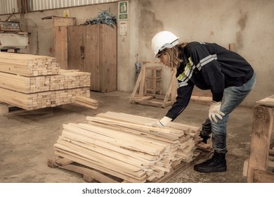 Confident female worker standing in lumber warehouse of hardwood furniture factory inspecting production machine. Serious female technician, engineer busy working with tool in woodwork manufacturing. - Powered by Shutterstock