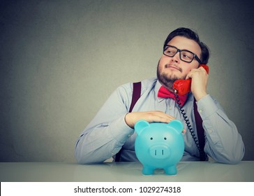 Confident Financial Advisor With Piggy Bank Callling On The Phone 