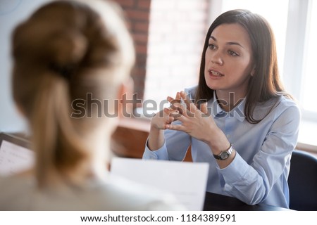 Confident focused businesswoman, teacher or mentor coach speaking to business people at negotiations, woman leader speaker applicant talking at meeting or convincing hr during job interview concept