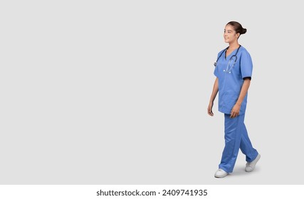 A confident and friendly Caucasian millennial healthcare worker in blue scrubs and stethoscope walking, exemplifying professionalism and approachability in medical attire - Powered by Shutterstock