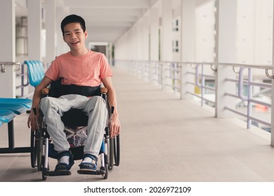 Confident Handicapped Teenager Boy On Wheelchair With Happy Face On Walk Way In Hospital, Smart Disabled Kid Activity To See A Doctor And Push Wheel By Himself,Mental Health Of Diverse People Concept.