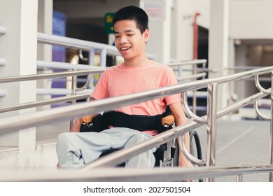 Confident Handicapped Teenager Boy On Wheelchair With Happy Face On Walk Way In Hospital, Smart Disabled Kid Activity To See A Doctor And Push Wheel By Himself,Mental Health Of Diverse People Concept.