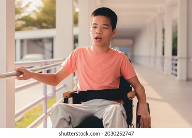 Confident Handicapped Teenager Boy On Wheelchair With Happy Face On Walk Way In Hospital, Smart Disabled Kid Activity To See A Doctor And Push Wheel By Himself,Mental Health Of Diverse People Concept.