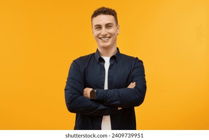 Confident handsome guy posing with arms crossed on chest and smiling at camera, wearing casual clothing, isolated on yellow studio background. Millennials lifestyle - Powered by Shutterstock