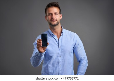 A Confident Handsome Young Man Showing His Phone To The Camera