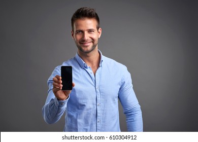 A Confident Handsome Young Man Showing His Phone To The Camera