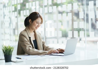 Confident Happiness Young Woman Working On Laptop Or Notebook In Her Office. Beautiful Freelancer Woman Working Online At Her Home. Beauty Asian Business Woman Concept.