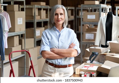 Confident happy mature older 60s woman retail seller, entrepreneur, clothing store small business owner, supervisor looking at camera standing arms crossed in delivery shipping warehouse, portrait. - Powered by Shutterstock