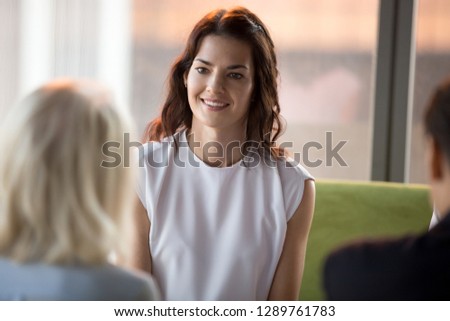 Confident happy millennial seeker applicant smiling looking at hr during job interview, young smiling businesswoman participating business meeting negotiations, recruiting, first impression concept