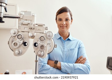 Confident, Happy And Proud Optometrist Standing With Arms Crossed, Ready For Checkup And Preparing Equipment In An Optometry Office. Smiling, Successful And Wellness Portrait Of An Ophthalmologist