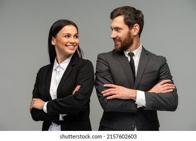 Confident happy young business partners looking at each other while posing isolated on grey background. Business concept  - Shutterstock ID 2157602603