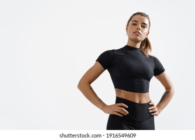 Confident healthy and athletic woman staring determined at camera, holding hands on hips. Sportswoman exercising in sport clothing, training and workout on white background. - Powered by Shutterstock