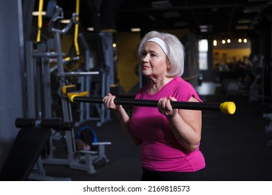 Confident Healthy Elderly Woman Exercising At The Gym, Doing Bicep Curls